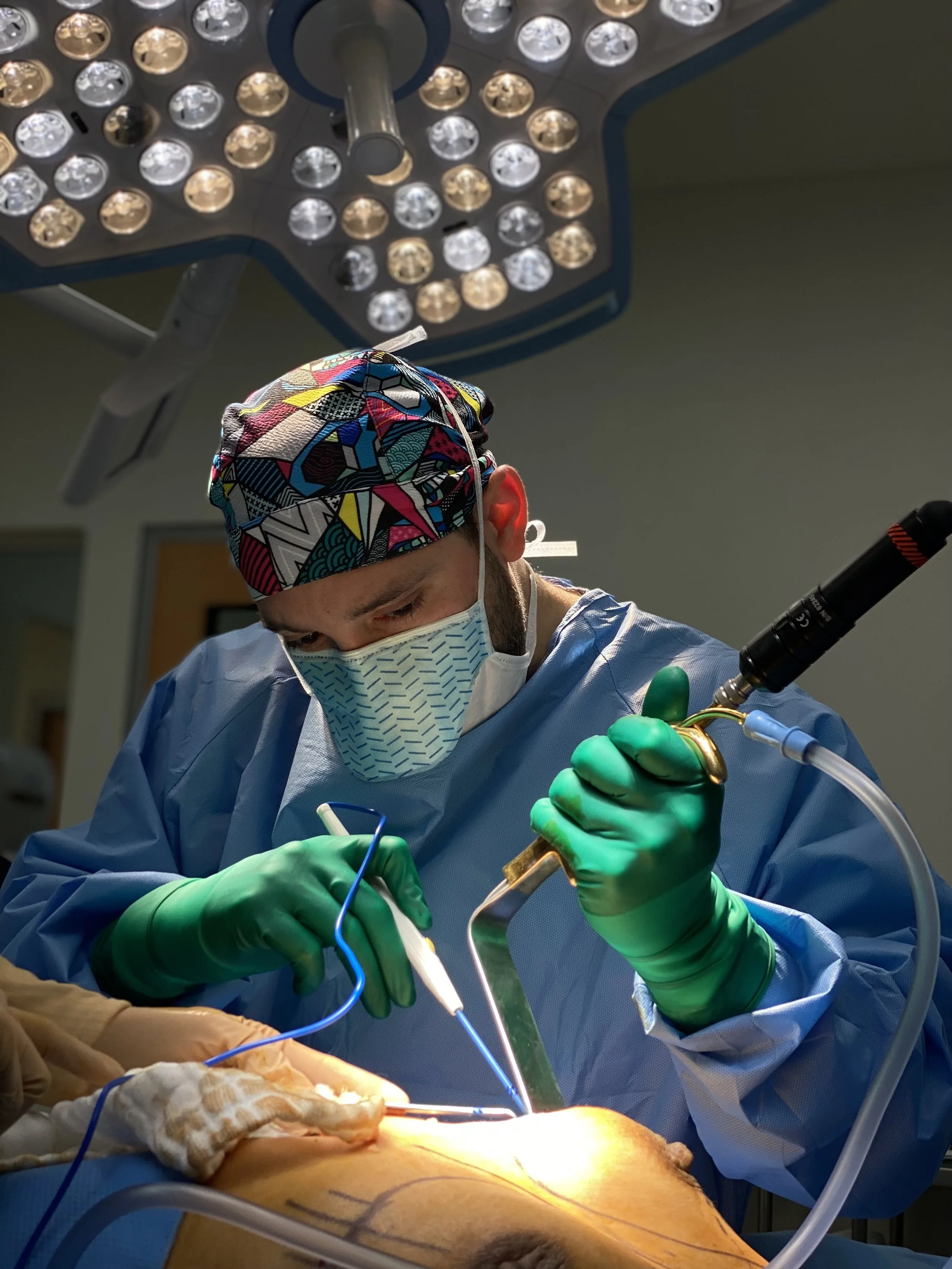 Dr. Carlos Marciales performing surgery under the operating lights